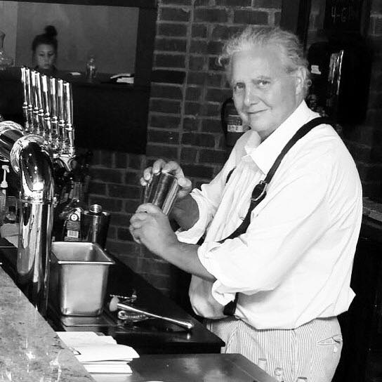 Chef Needham mixes vintage cocktails behind the bar.